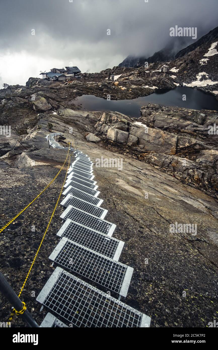 Scalinata per villaggio alpino e stagno Foto Stock