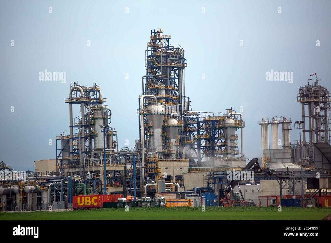 Raffineria chimica con contenitori per il trasporto di merci da ubc Transport Logistics Company in primo piano. Aprile 2013. Vienna, Austria Foto Stock