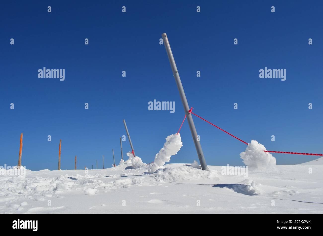 Colonne di ferro e legno, corda rossa, molta neve e cielo limpido, stazione sciistica di montagna Kopaonik, Serbia Foto Stock