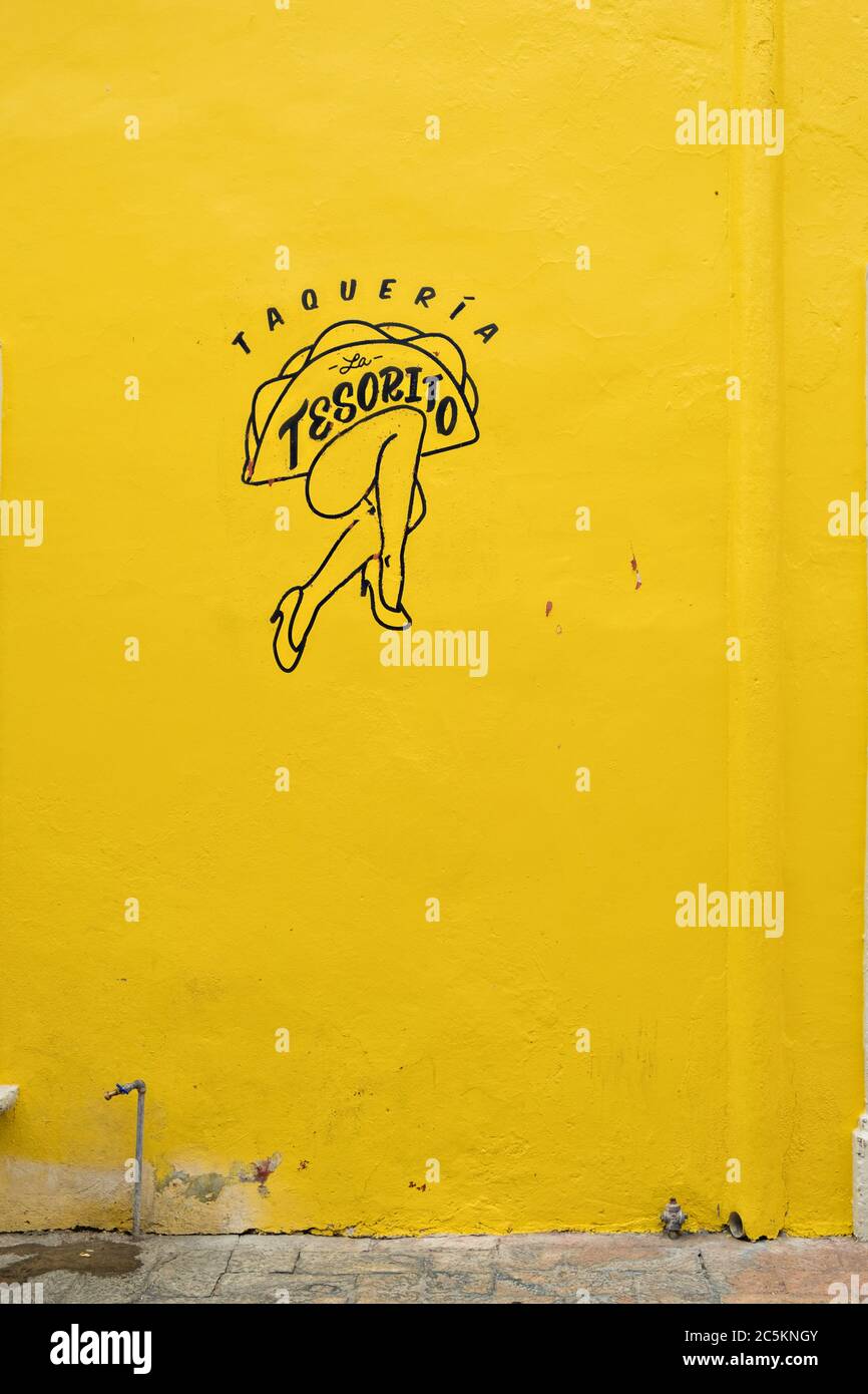 Un annuncio per un Taco Bar dipinto su una parete di colore giallo brillante nella vecchia sezione coloniale di Santiago de Queretaro, Stato del Queretaro, Messico. Foto Stock