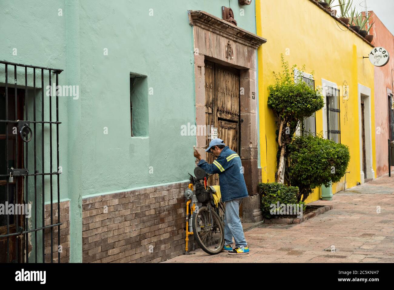 Un anziano messicano affilando coltelli lungo un vicolo colorato nella vecchia sezione coloniale di Santiago de Queretaro, Stato Queretaro, Messico. Foto Stock