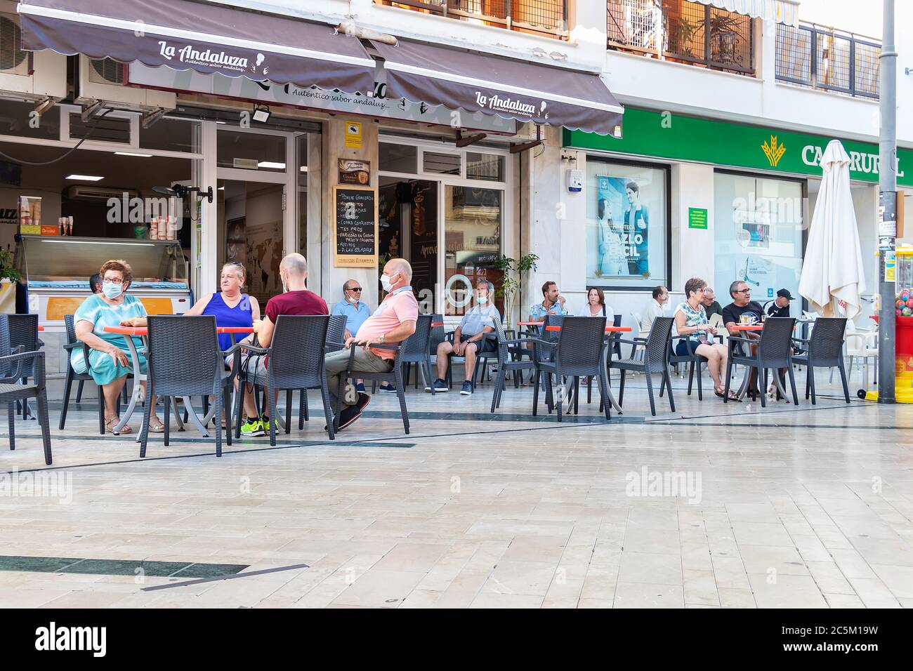 Punta Umbria, Huelva, Spagna - 3 giugno 2020: Persone sedute in terrazza di un bar e caffetteria in via calle Ancha di Punta Umbria, Huelva, Spagna Foto Stock
