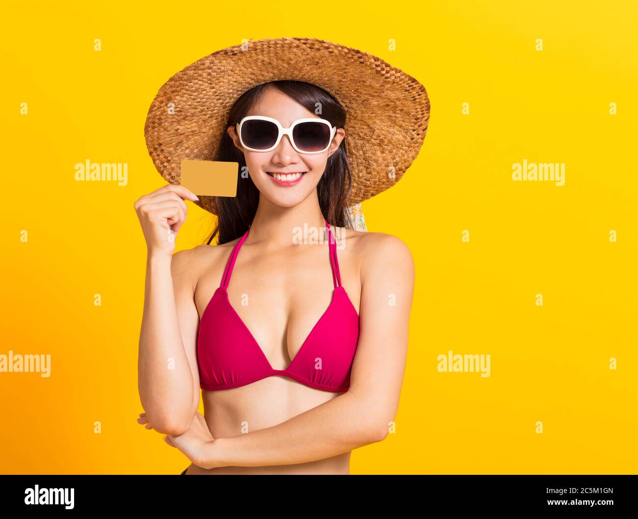 giovane bella donna che indossa il costume da bagno bikini e mostrando la carta di credito Foto Stock