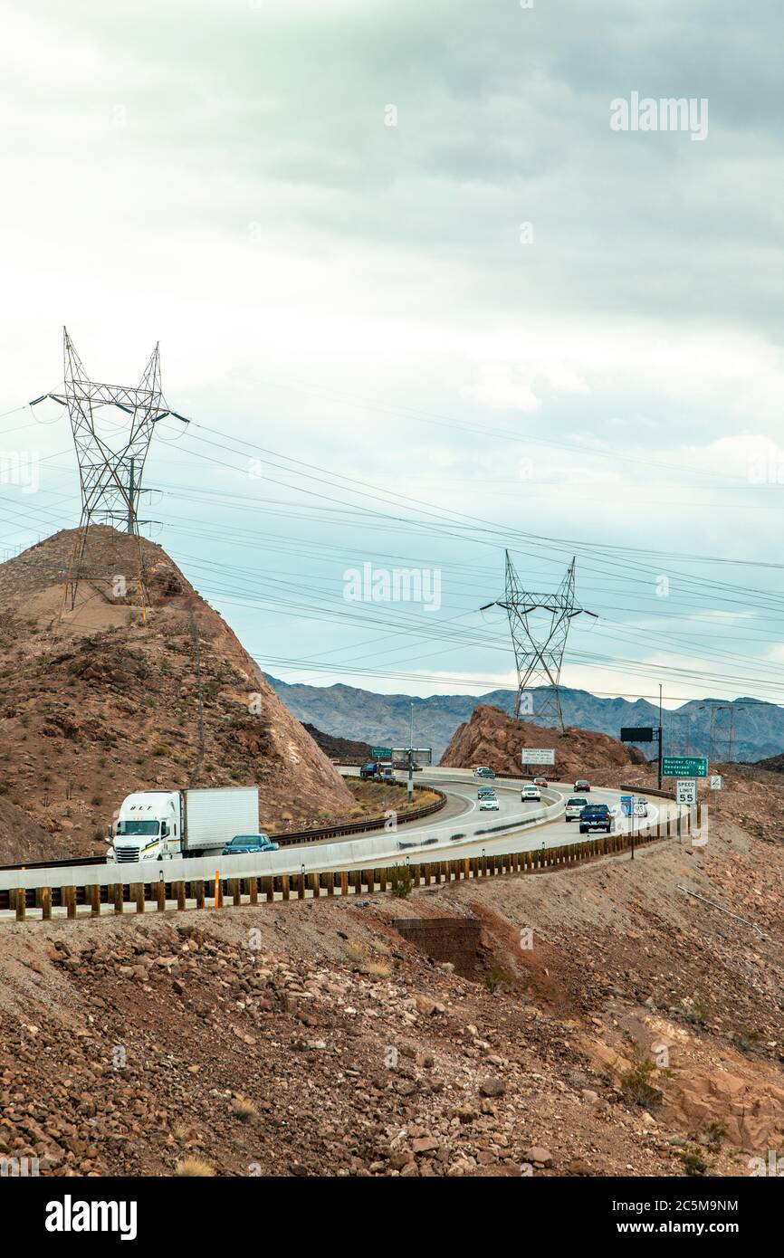 White Truck che passa su un'autostrada del deserto vicino Mojave, Las Vegas, Nevada, USA di fronte alle grandi torri di cavo. Foto Stock