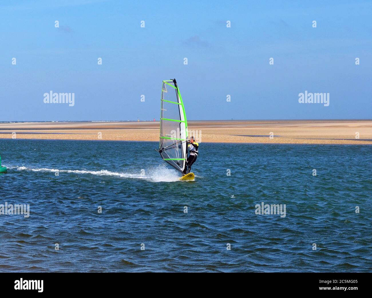 Windsurf sull'estuario che attraversa Wells Next The Sea Beach, Norfolk, Regno Unito Foto Stock