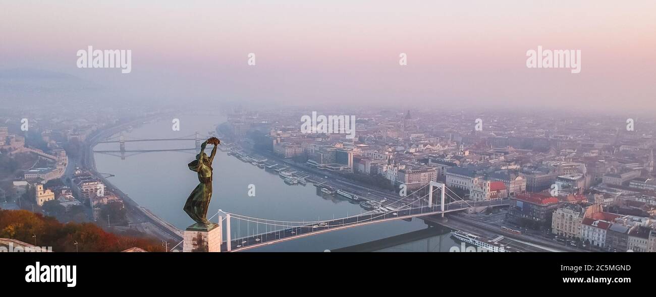 Vista aerea della Statua della libertà con il Ponte Elisabetta e il Danubio, preso dalla collina di Gellert all'alba nella nebbia a Budapest, Ungheria. Foto Stock