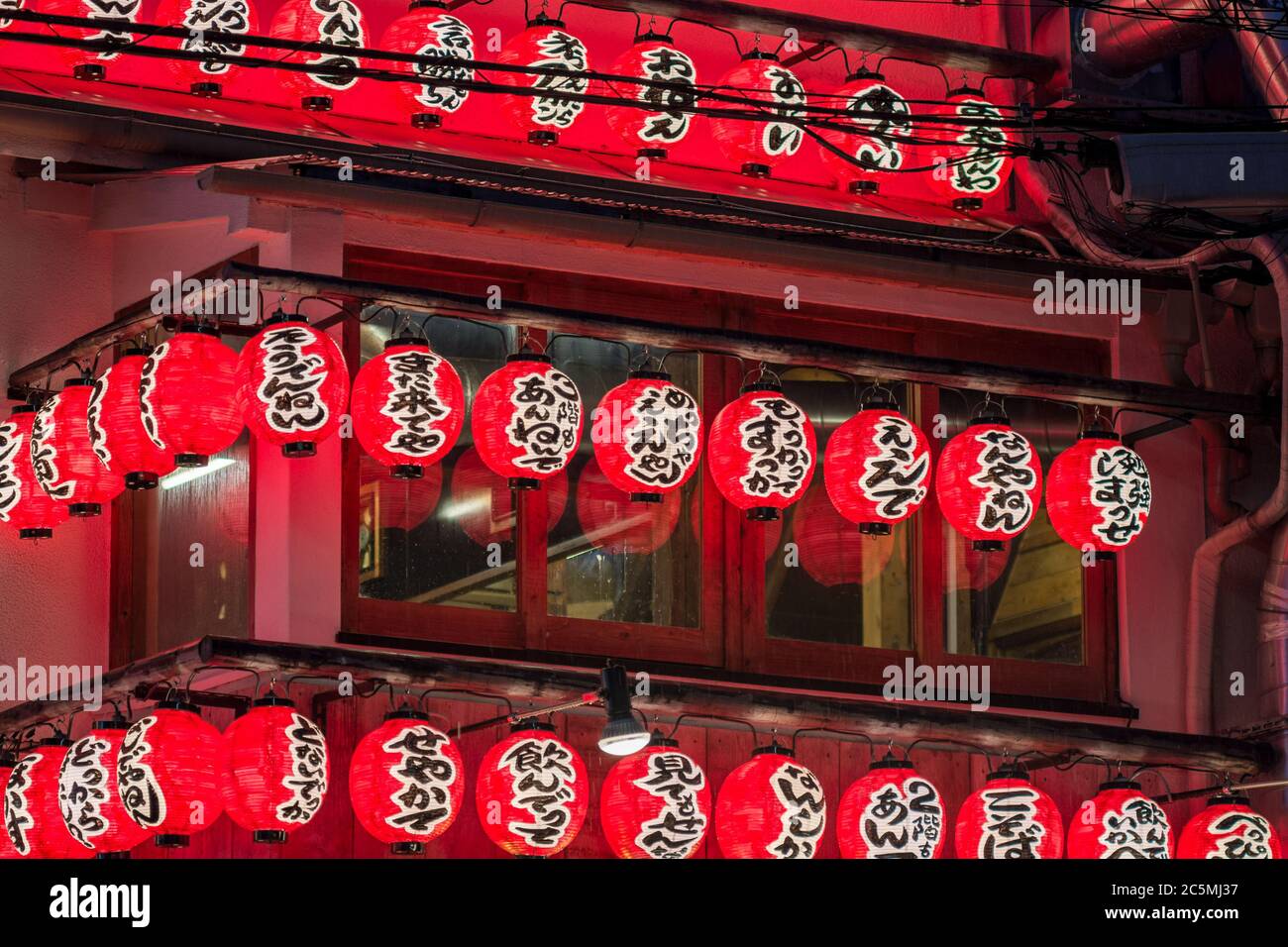 Osaka / Giappone - 19 marzo 2018: Lanterne rosse luminose che pubblicizzano un ristorante e bar Izakaya nell'area di Dotonbori nel centro di Osaka. Un izakaya è un tipo Foto Stock