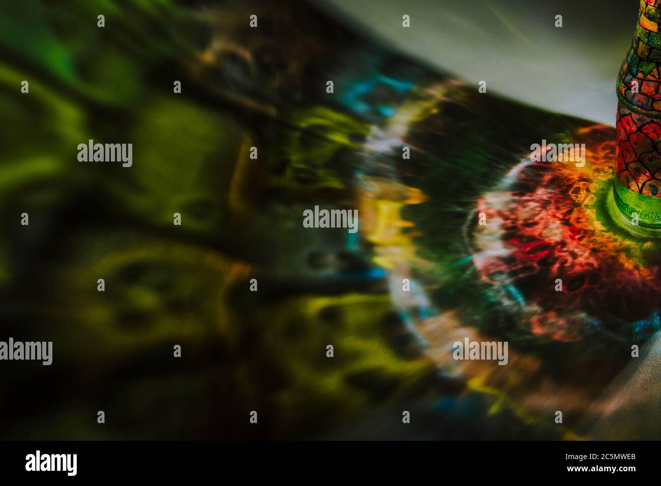 luce che passa attraverso una bottiglia con arte colorata Foto Stock