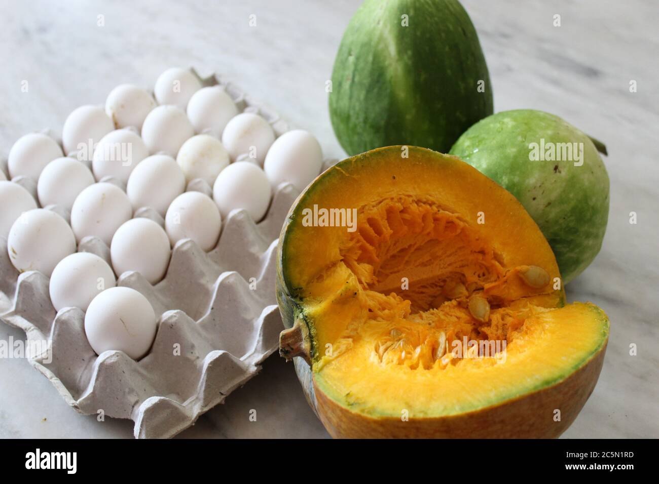 Uova e verdure insieme mostrano con fondo bianco pavimento. Foto Stock