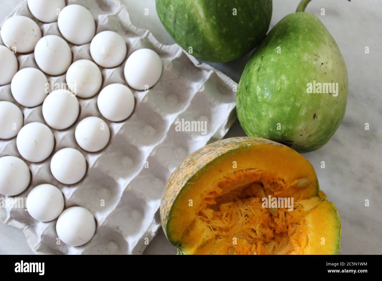 Uova e verdure insieme mostrano con fondo bianco pavimento. Foto Stock