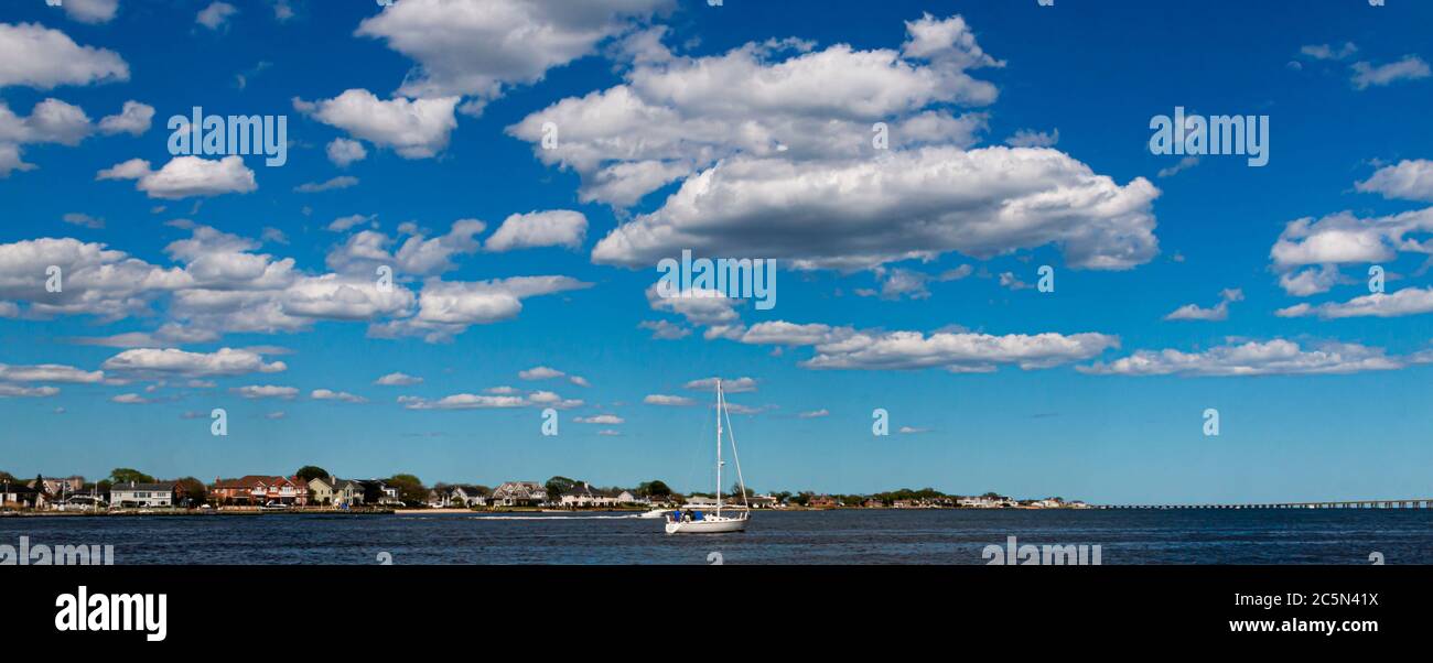 Una barca a vela nella Grande Baia del Sud con cielo molto blu e spesse nuvole bianche soffici sopra. Foto Stock