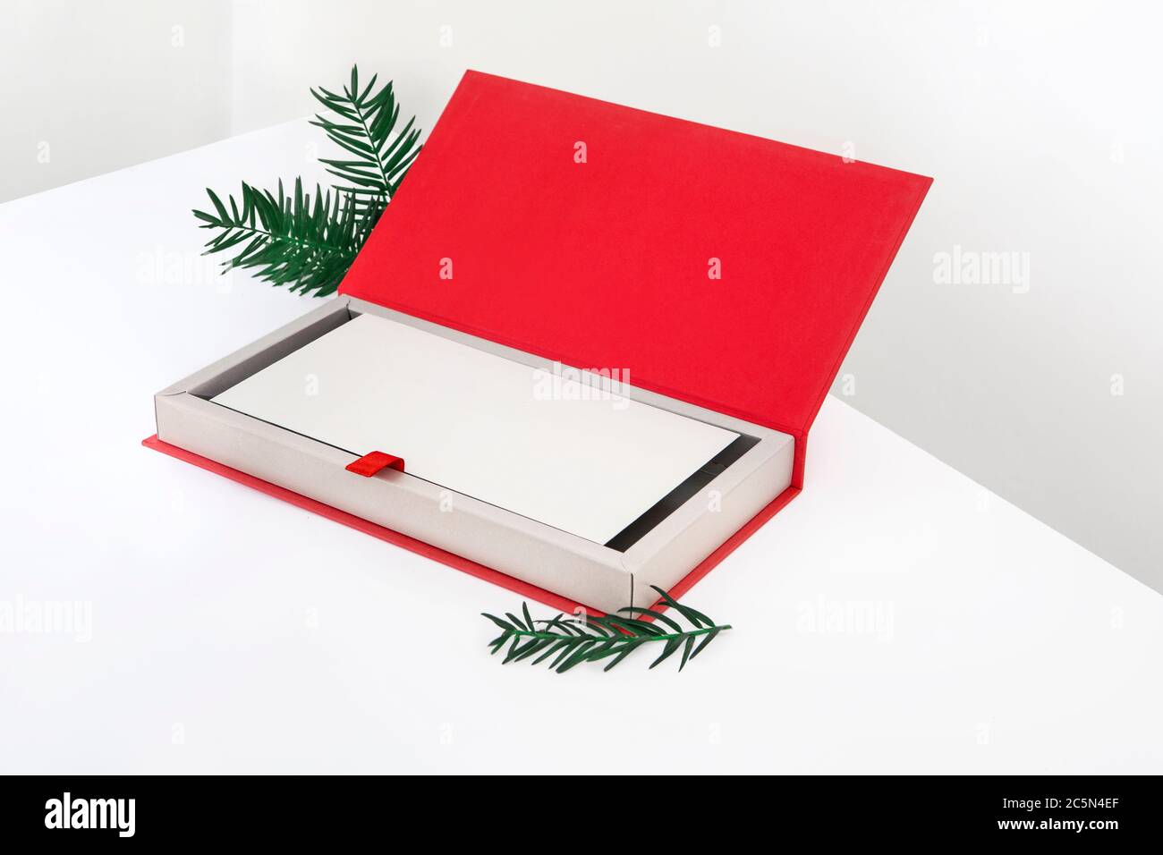apri la scatola rossa di natale per regali e carte regalo con foglie di  pino su sfondo bianco Foto stock - Alamy