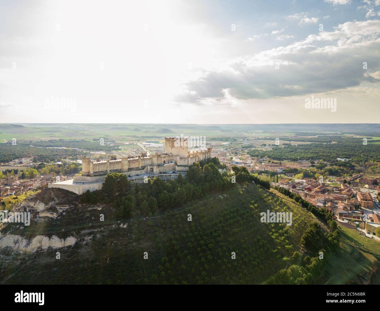 Veduta aerea del famoso castello di Peñafiel a Valladolid al tramonto, con il borgo antico e le cantine sullo sfondo. Foto Stock