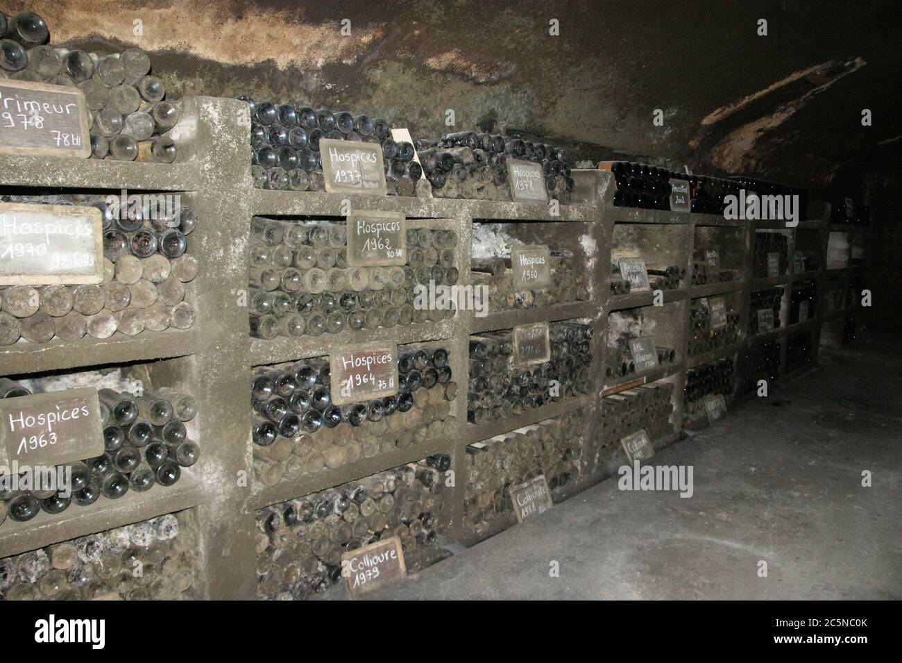 Una selezione dei vini che invecchiano e si radunano sotto polvere nelle grotte dei Templiers in uso per molti secoli. Foto Stock