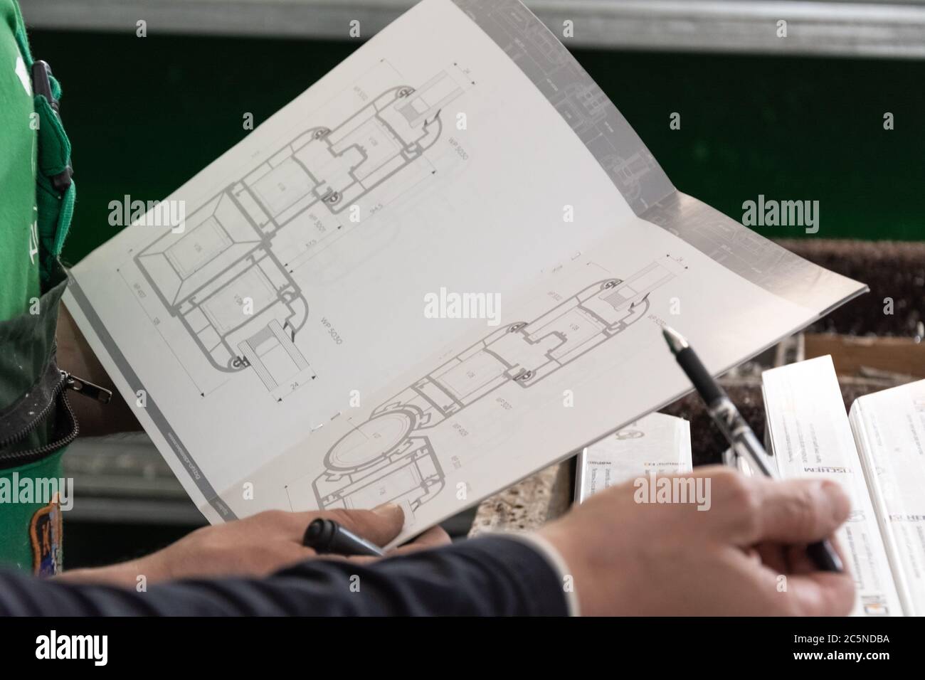 I lavoratori studiano le finestre di upvc disegnando su finestre e porte di upvc fabbrica Foto Stock
