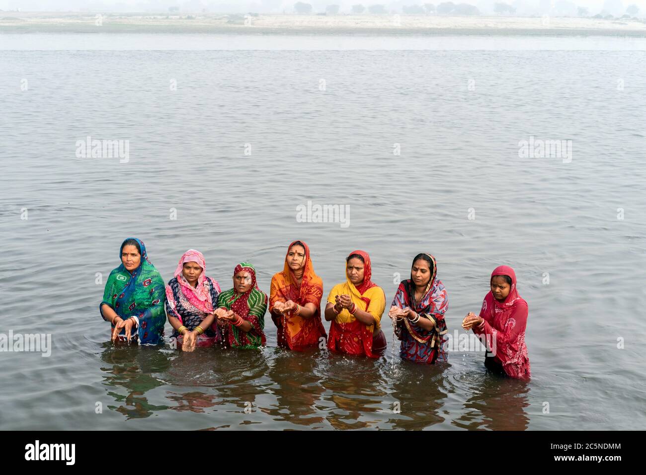 Le donne indù offrono preghiere a Dio indù dopo un bagno rituale nel fiume Yamuna santo in Vrindavan, Uttar Pradesh, India. Foto Stock