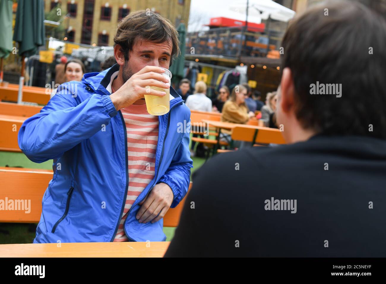 La gente gusteranno bevande al bar Acetar Yard, Londra, riaprirsi dopo l'allentamento delle restrizioni di blocco del coronavirus in tutta l'Inghilterra. Foto Stock