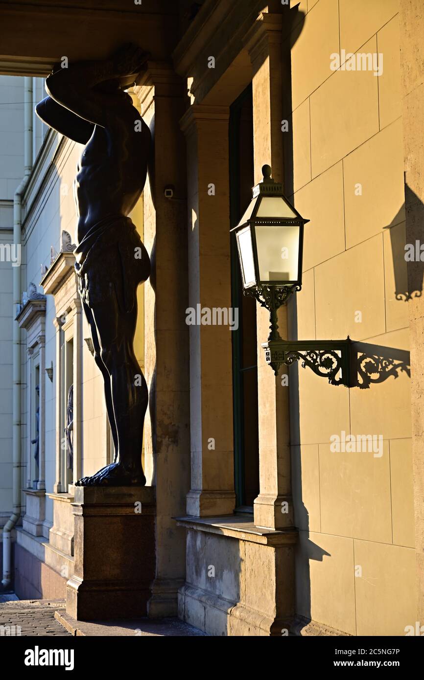 Atlante (atlante) scultura di granito di un uomo che sostiene la colonna del Museo dell'Hermitage del Palazzo d'Inverno a San Pietroburgo, Russia mostrata al tramonto Foto Stock