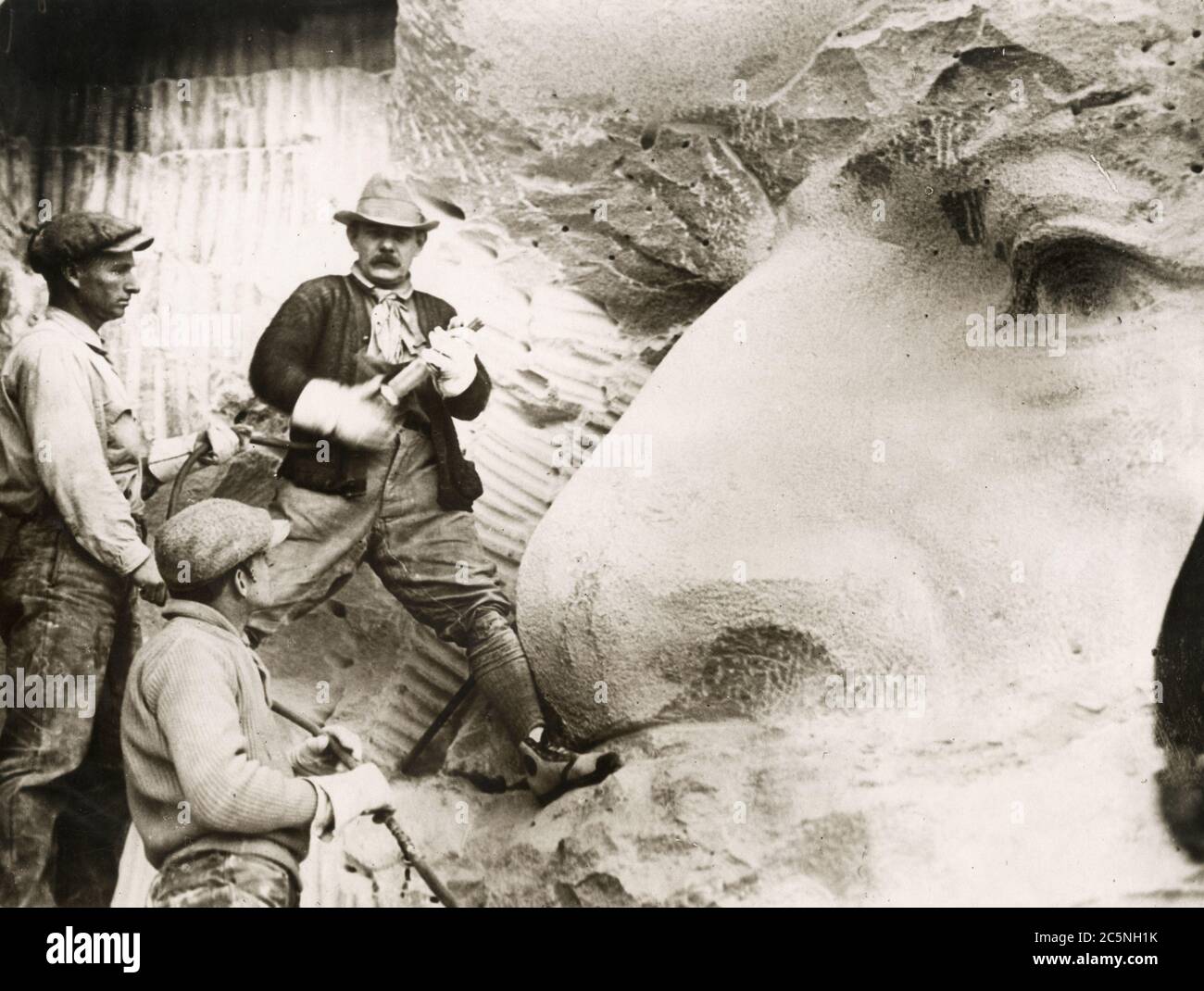 1925 fotografia di stampa d'epoca dello scultore controverso Gutzon Borglum che mette i tocchi finali alla testa del generale Lee sul memoriale confederato costruito nella faccia di Stone Mountain, Georgia. Il prossimo grande progetto di Borglum fu il Monte Rushmore. Foto Stock
