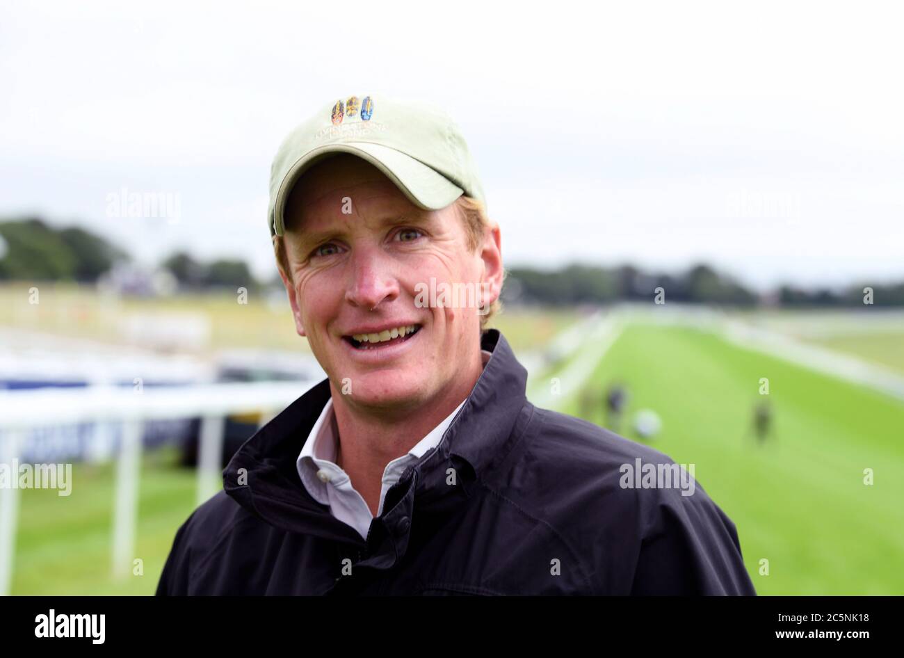 L'allenatore di cavalli ed Walker cammina il corso prima dell'inizio delle gare all'Ippodromo di Epsom. Foto Stock