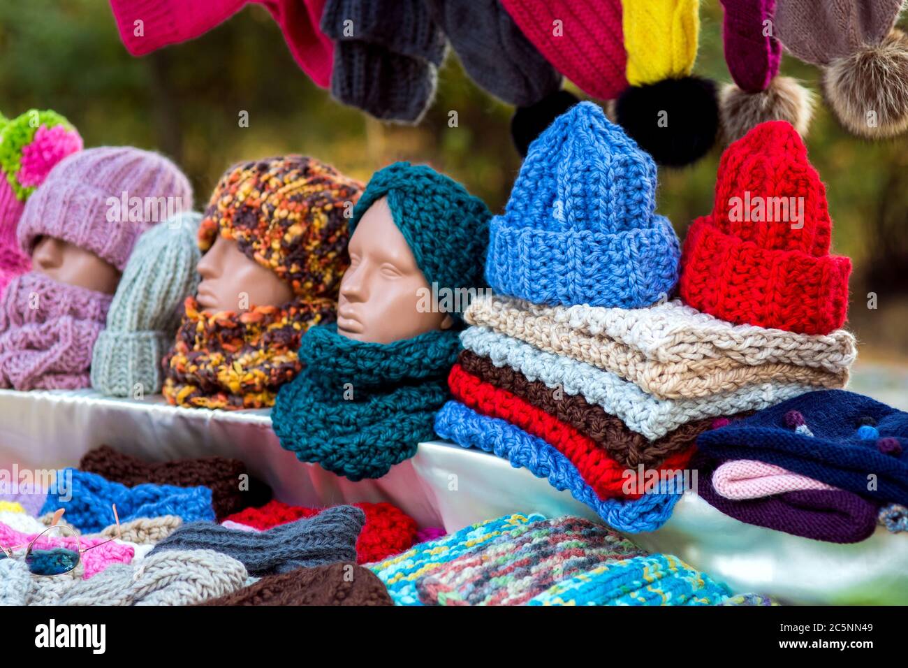 Controsoffilo con cappelli in lana e sciarpe colorate con testa manichino. Foto Stock