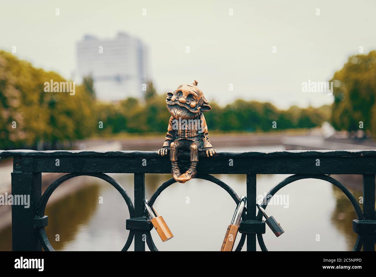 Un vecchio uomo in bronzo Homestlin siede sulla ringhiera del ponte Foto Stock