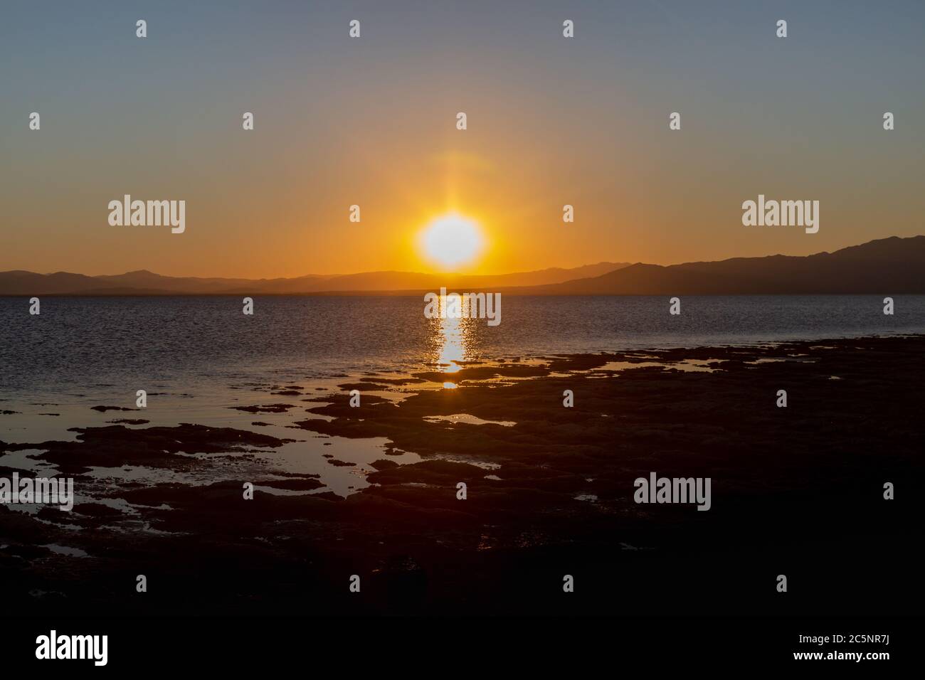 Il sole tramonta dietro le colline del Salton Sea in California Foto Stock