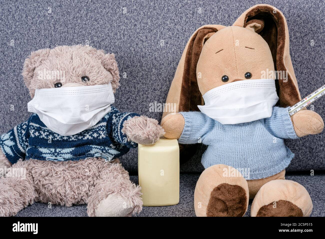 Arrestare virus COVID -19. I giocattoli portano e coniglietto sono seduti in maschere mediche di protezione. Concetto di protezione antivirus. L'orso di Teddy e il coniglietto tengono il sapone nella loro p Foto Stock