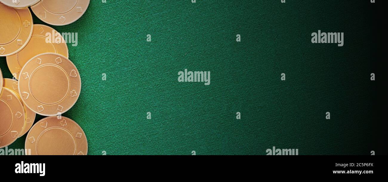 Template banner Casino con gettoni e monete d'oro sul tavolo da poker. Superficie tessile verde. Design piatto. Spazio di copia per l'annuncio Foto Stock
