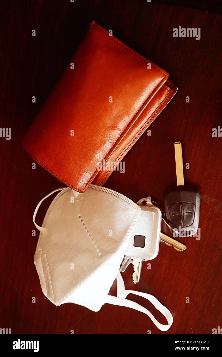 pronto per uscire con gli oggetti di ogni giorno: maschera di protezione covid per prevenire l'infezione, portafoglio e chiavi Foto Stock