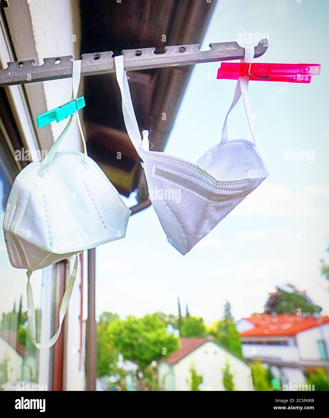 Maschere di protezione Covid appese al sole sul balcone dopo la disinfezione Foto Stock