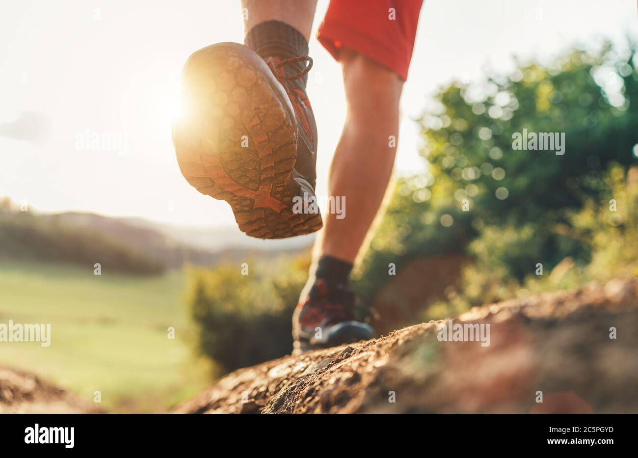 Scarpe da trekking suola primo piano immagine viaggiatore piedi in scarpe da trekking su montagna sporco percorso in estate. Foto Stock