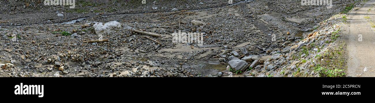 Sentiero escursionistico lungo un ruscello asciutto di un torrente di montagna con massi nel Tirolo orientale, Austria Foto Stock