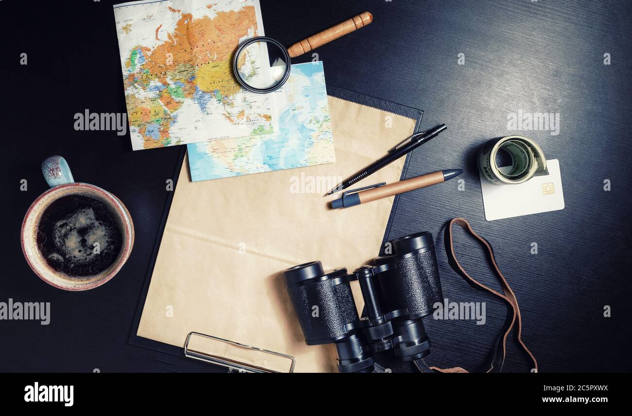 Preparazione per il viaggio. Dispositivi turistici su sfondo nero tavolo. Disposizione piatta. Foto Stock