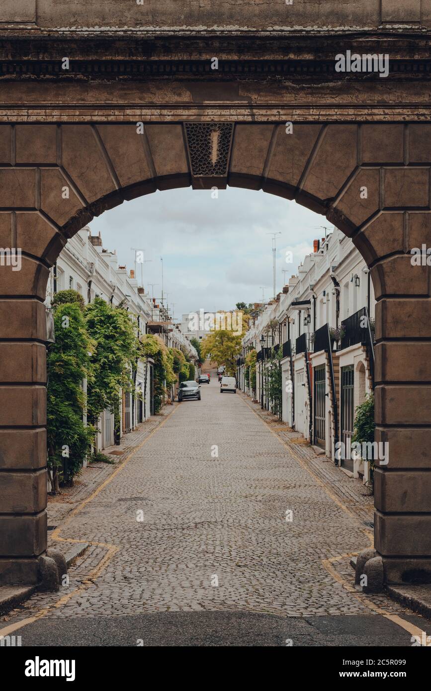 Londra, UK - 20 giugno 2020: Vista di Holland Park Mews attraverso l'arco delle sotne. Le case a mews sono una delle proprietà più lussuose e desiderabili in Foto Stock