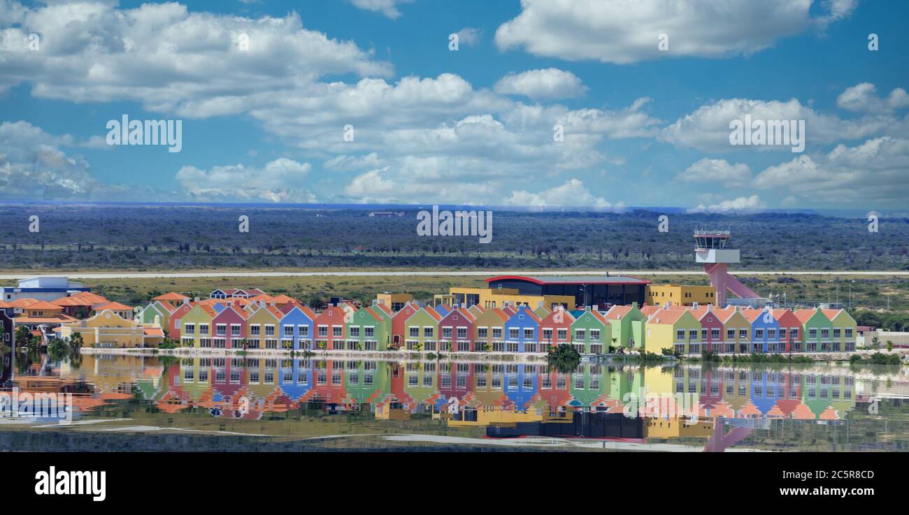 Fila colorata di edifici lungo il bacino riflettente Foto Stock
