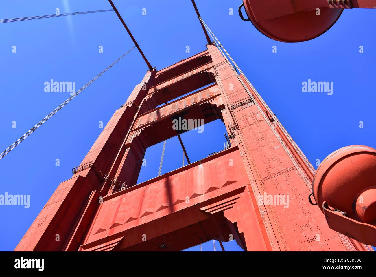 Guardando verso l'alto da sotto la Torre Sud dal Golden Gate Bridge. Cielo blu luminoso e ponte internazionale arancione. San Francisco, California. Foto Stock