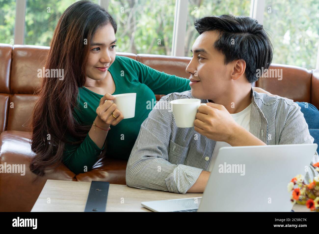 Happy Asian coppia bere caffè a casa. Foto Stock