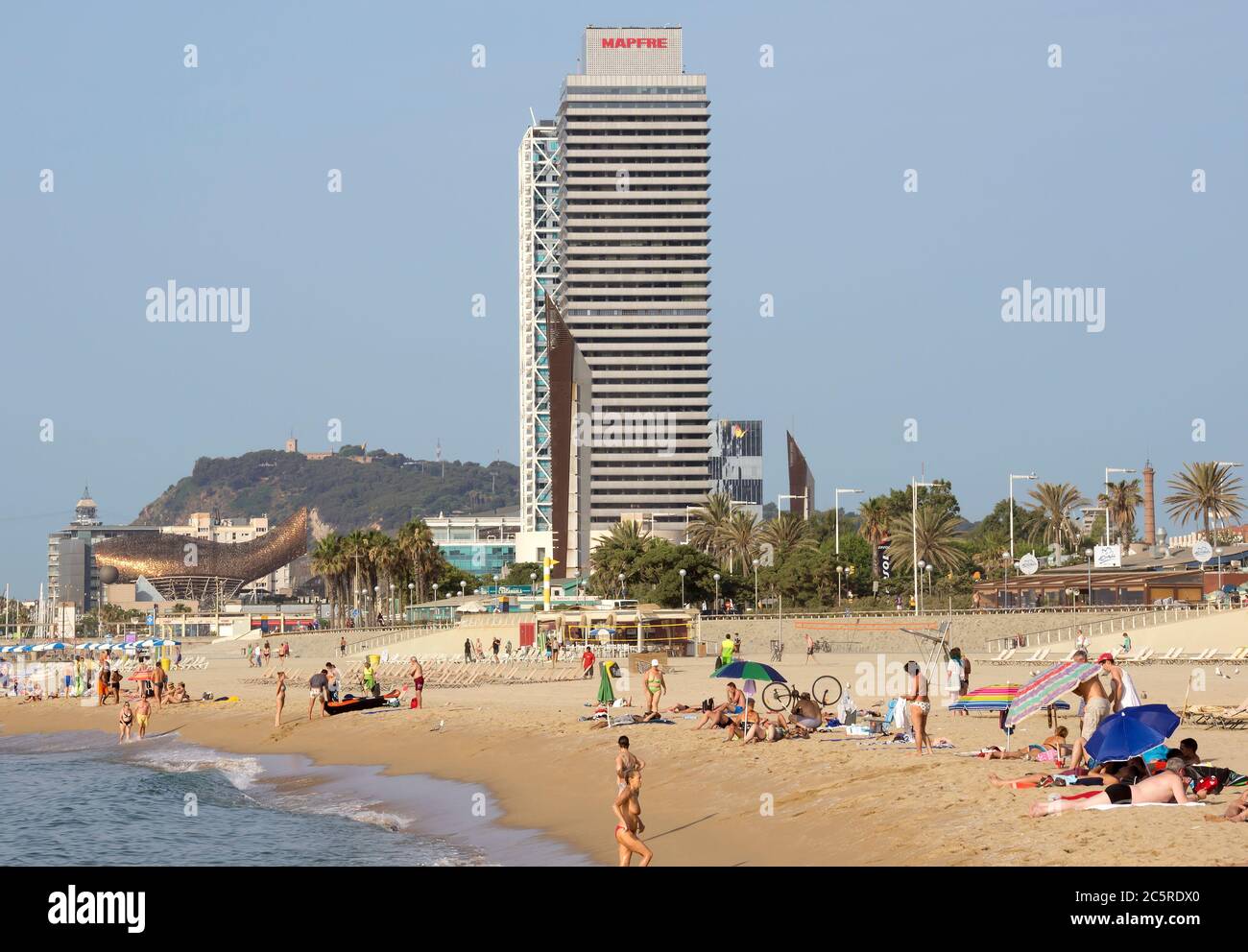 BARCELLONA, SPAGNA - 5 LUGLIO 2015: Spiaggia di Barceloneta e grattacielo Torre Mapfre nel Porto Olimpico. Prende il nome dal suo proprietario, Mapfre, un'assicurazione Foto Stock