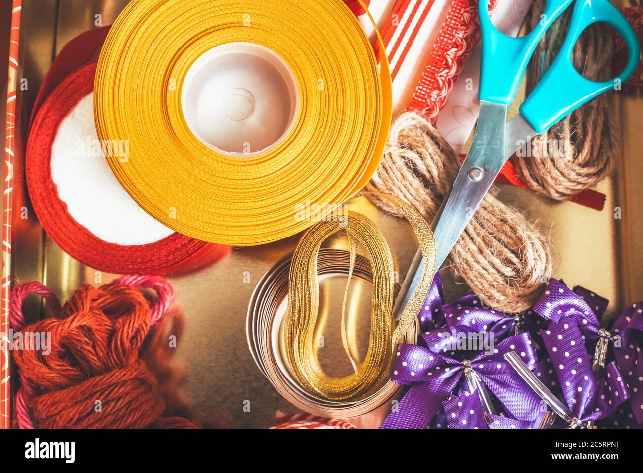 Rotolo di corda, nastro e prua regalo nella scatola. Foto Stock