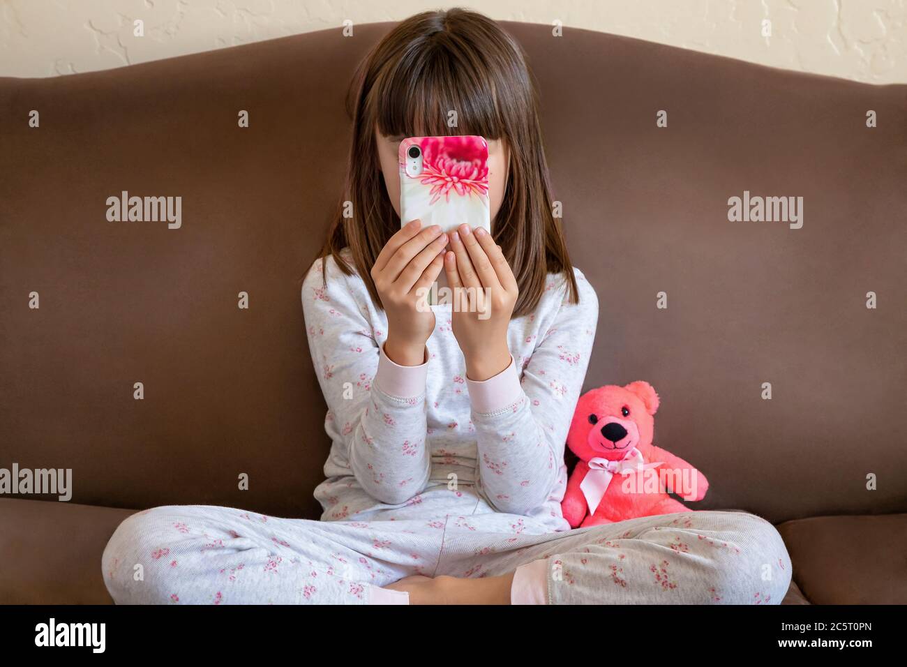 Ragazza di otto anni che gioca su un cellulare Foto Stock