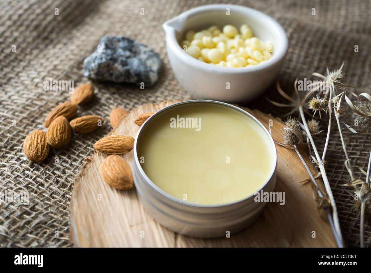 burro di cacao in granuli e mandorle su legno Foto Stock