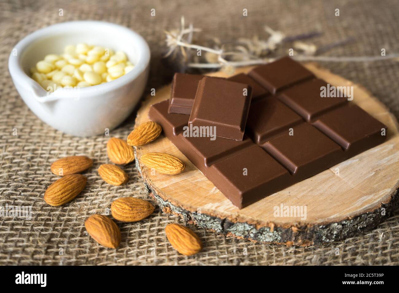 cioccolato con burro di cacao e mandorle su legno Foto Stock