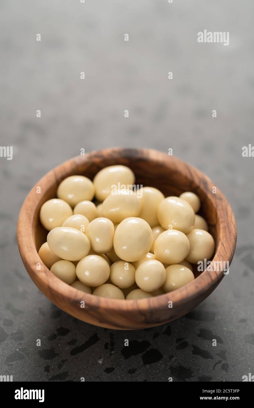 Draga di cioccolato bianco o yogurt con frutti di bosco ciotola su fondo di cemento Foto Stock