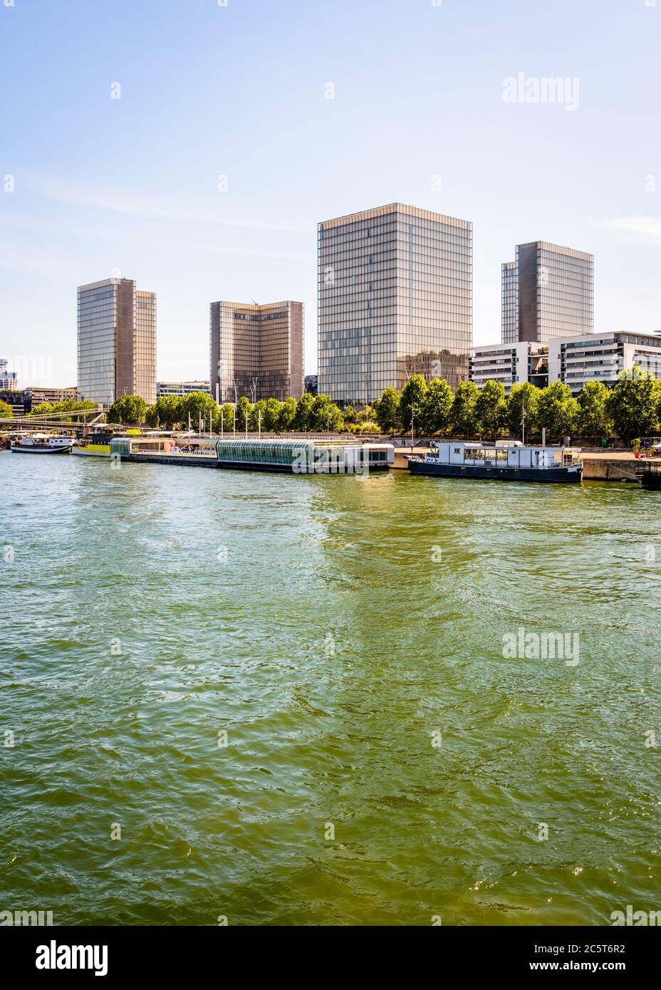 La biblioteca nazionale Francois Mitterrand sulle rive della Senna a Parigi, Francia, e la piscina galleggiante Josephine Baker in primo piano. Foto Stock