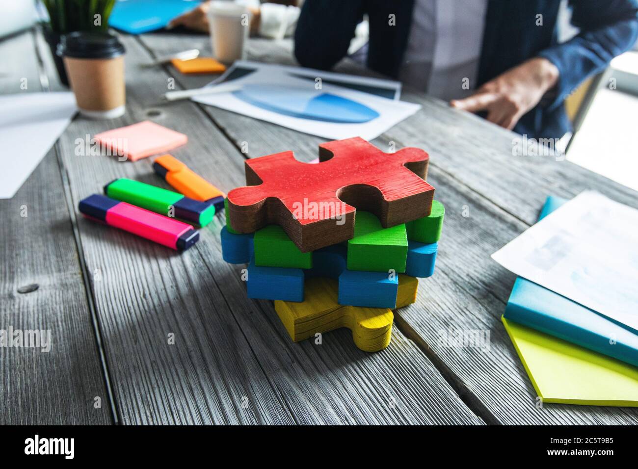 Pezzi di puzzle su tavolo da ufficio, visione aziendale e concetto di soluzione dei problemi Foto Stock