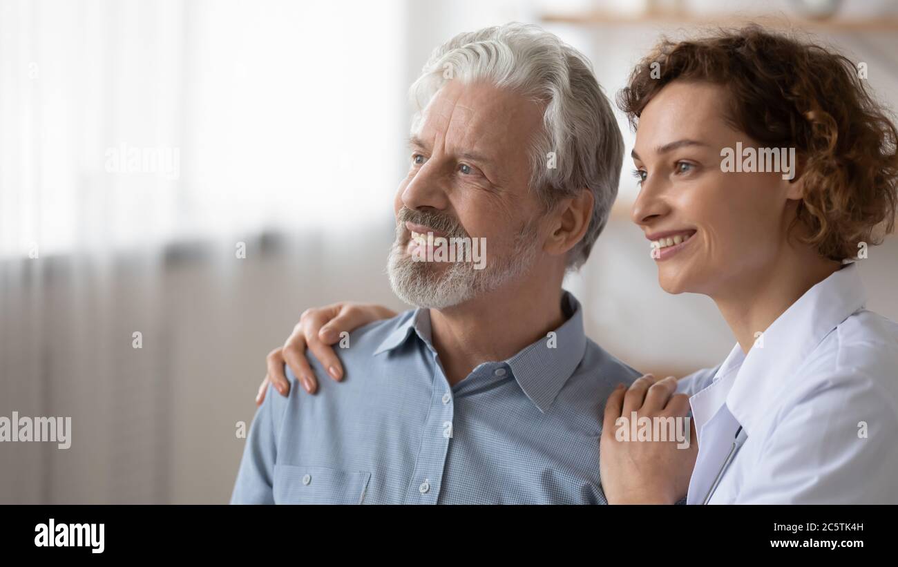 Sorridente donna infermiera sogno di un futuro sano con paziente anziano Foto Stock