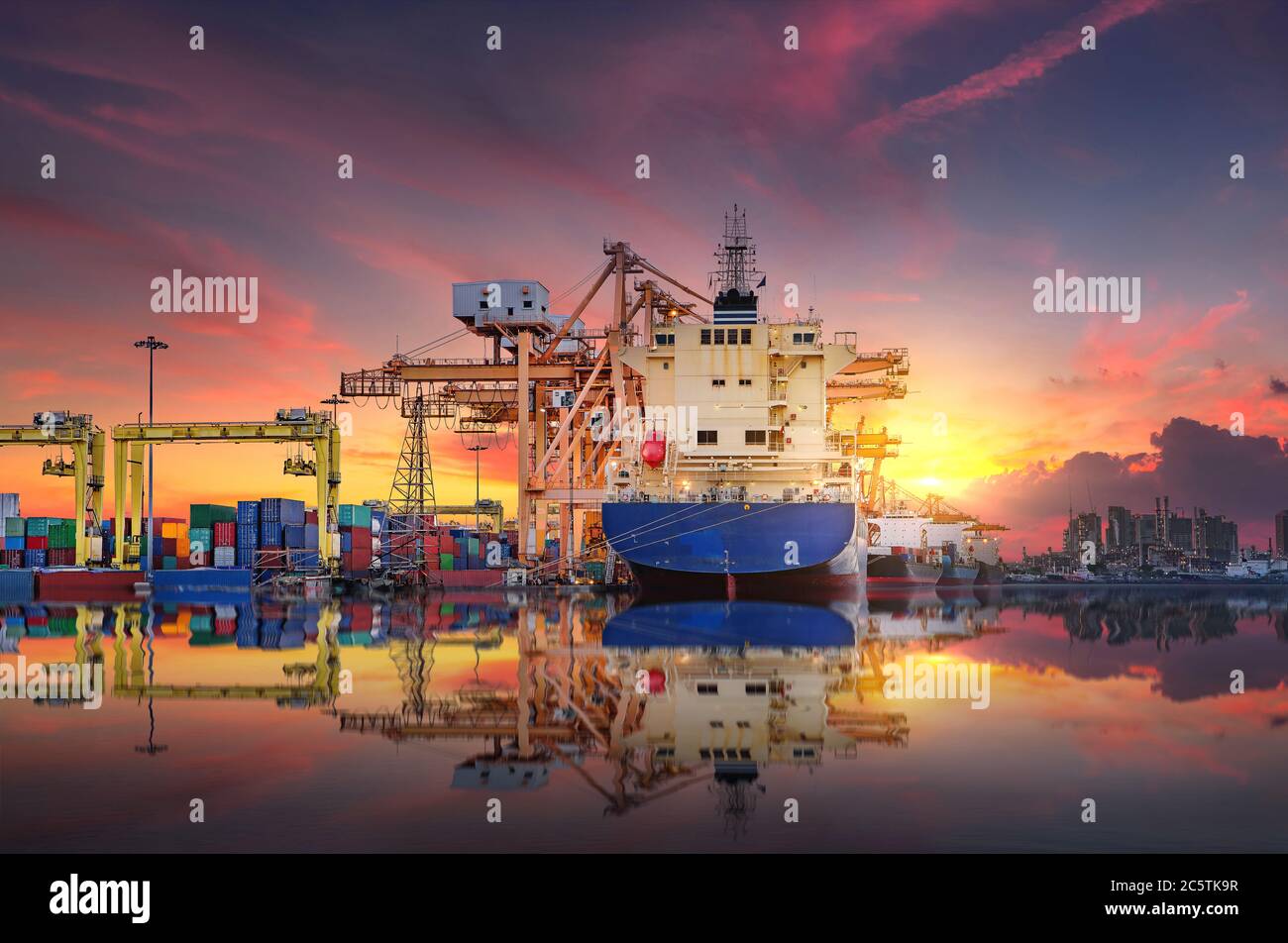 Il trasporto di navi da carico, container e la bellezza del riflesso dell'acqua al porto quando il cielo dopo il tramonto nel settore mi ha impegnato Foto Stock