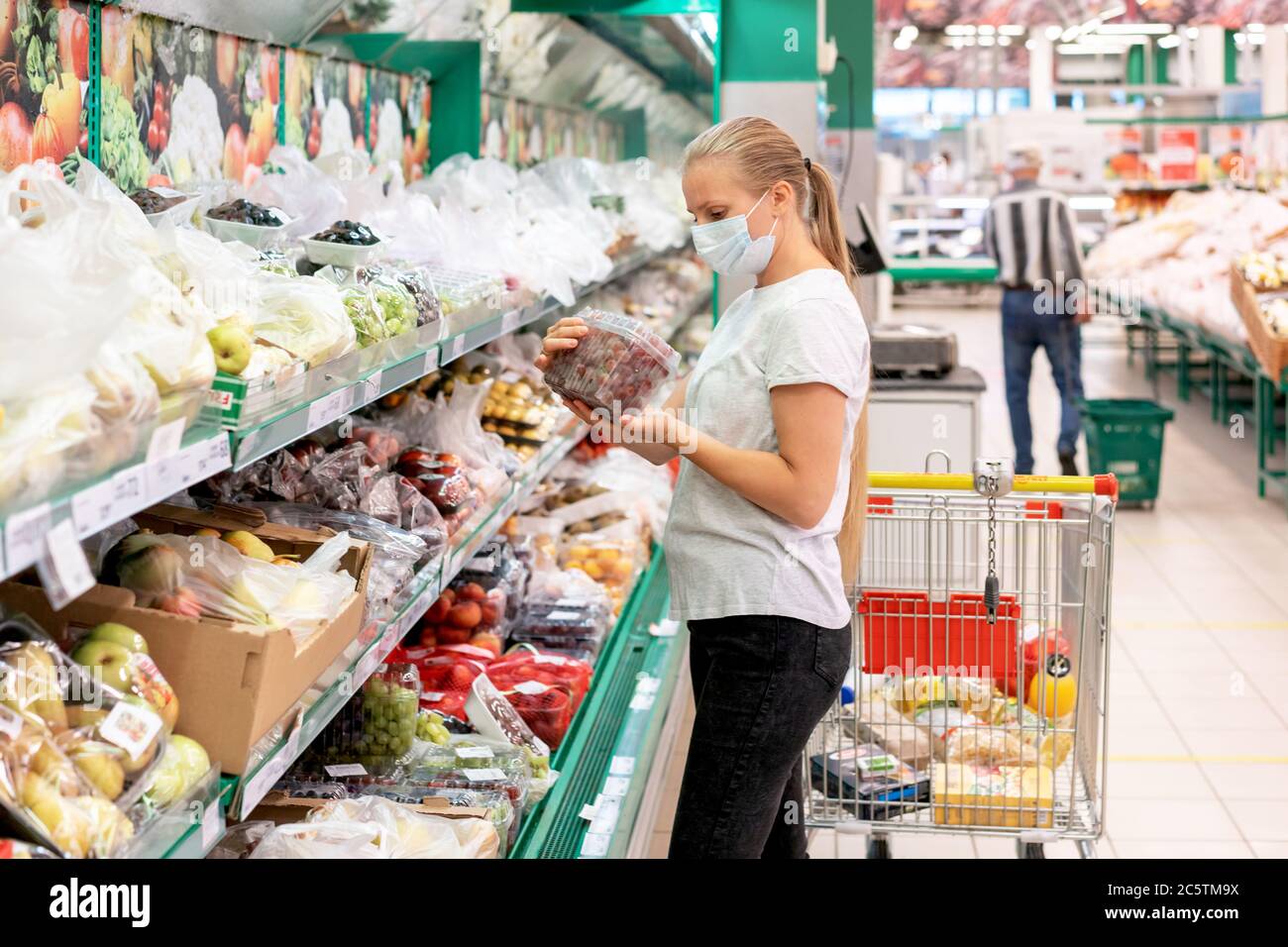 donna supermercato maschera verdure Foto Stock