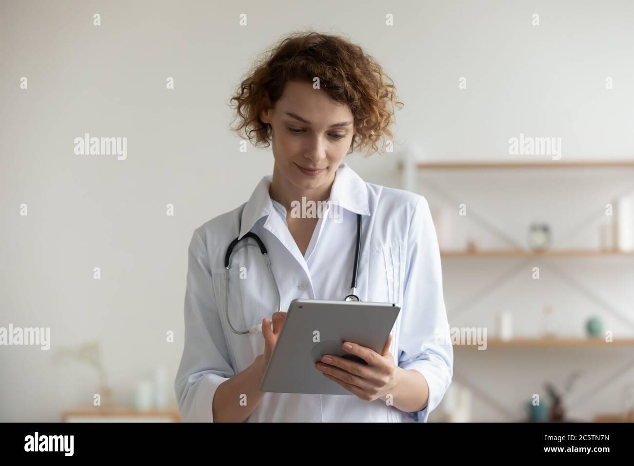 Medico femminile consultare il paziente online su una compressa Foto Stock